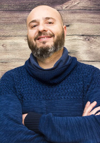 Bonito, homem careca com barba em um fundo de madeira — Fotografia de Stock