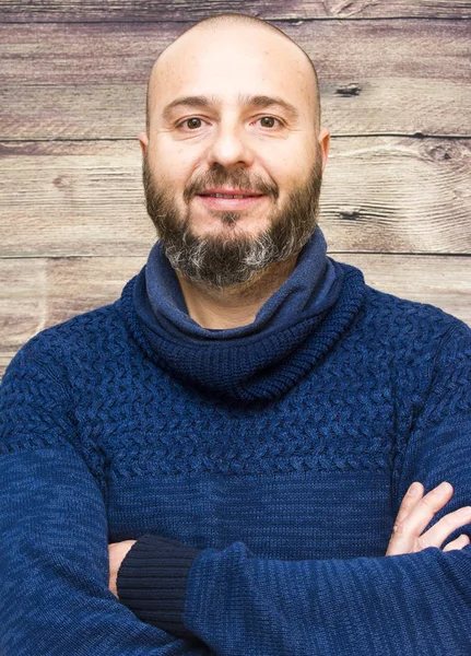 Bonito, homem careca com barba em um fundo de madeira — Fotografia de Stock