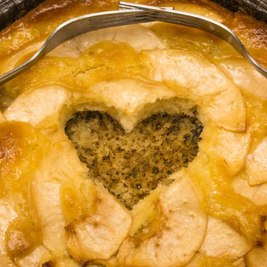 Elmalı turta kalp şeklinde bir oyuk ve iki çatal üzerinde dolaşık bir