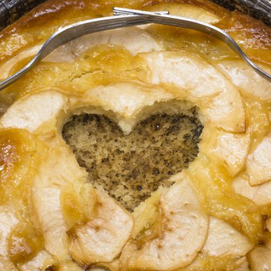 Elmalı turta kalp şeklinde bir oyuk ve iki çatal üzerinde dolaşık bir