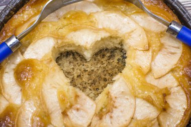 Elmalı turta kalp şeklinde bir oyuk ve iki çatal üzerinde dolaşık bir