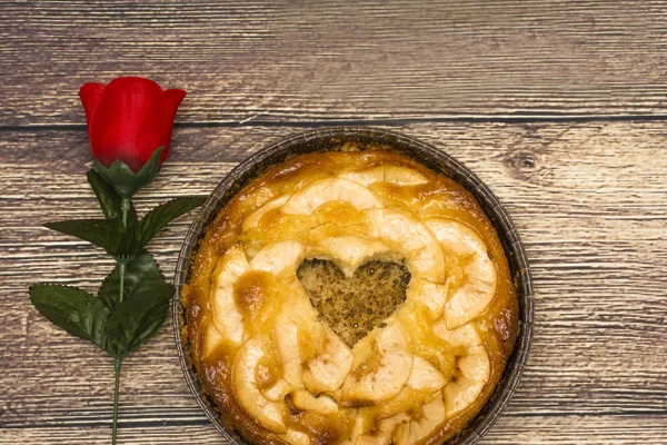 Torta di mele con un cavo a forma di cuore su una tavoletta di legno — Foto Stock