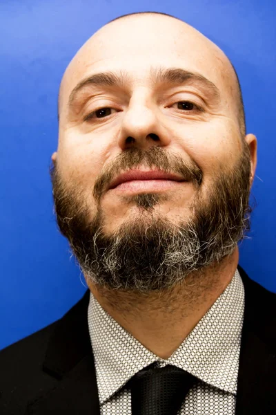 Handsome, bald man with beard, with suit and tie, on blue backgr — Stock Photo, Image