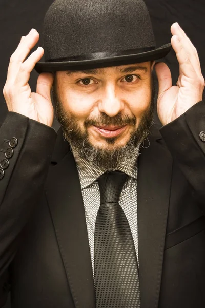 Bello uomo calvo con barba, completo, cravatta e cappello, sulla schiena nera — Foto Stock