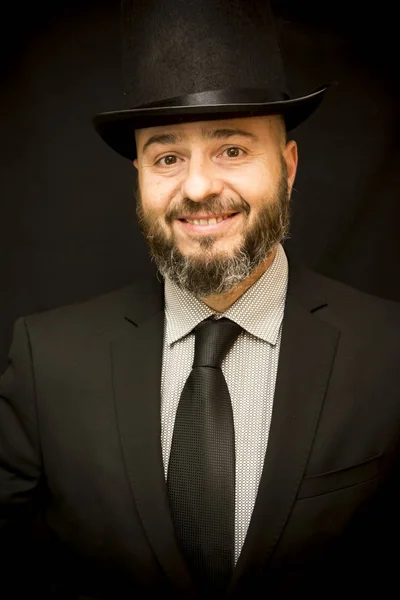 Schöner, glatzköpfiger Mann mit Bart, Anzug, Krawatte und Hut, auf schwarzem Rücken — Stockfoto
