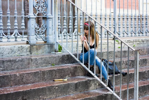 Portrét krásné ženy sedící na staré kamenné schodiště — Stock fotografie