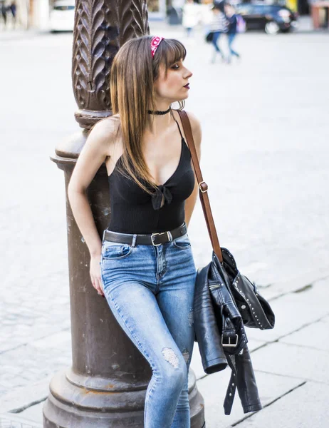 Mooie vrouw op straat leunend op een lantaarnpaal — Stockfoto