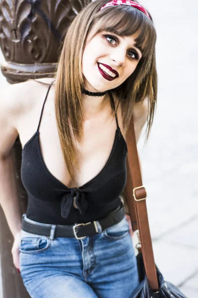 Beautiful woman on the street leaning on a lamppost — Stock Photo, Image