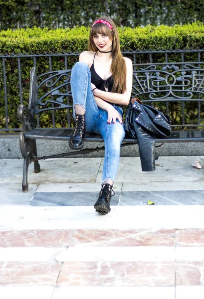 Retrato de uma mulher bonita na rua sentada em um banco — Fotografia de Stock