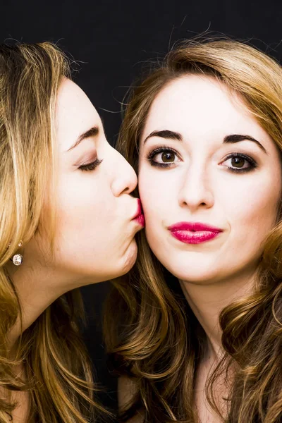 Duas mulheres bonitas onde um deles está dando um beijo no c — Fotografia de Stock