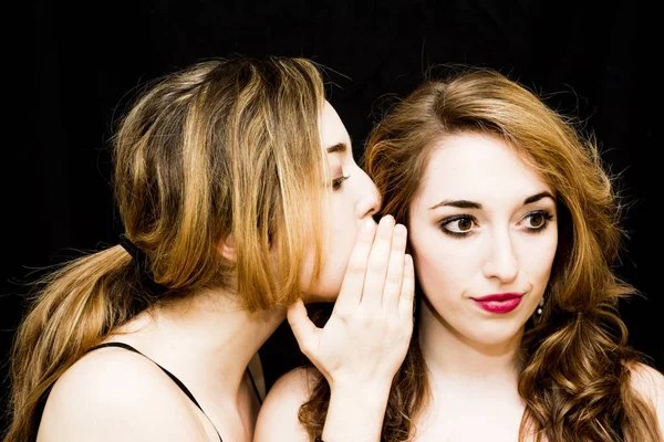 Dos mujeres hermosas donde una de ellas está contando un secreto a la — Foto de Stock