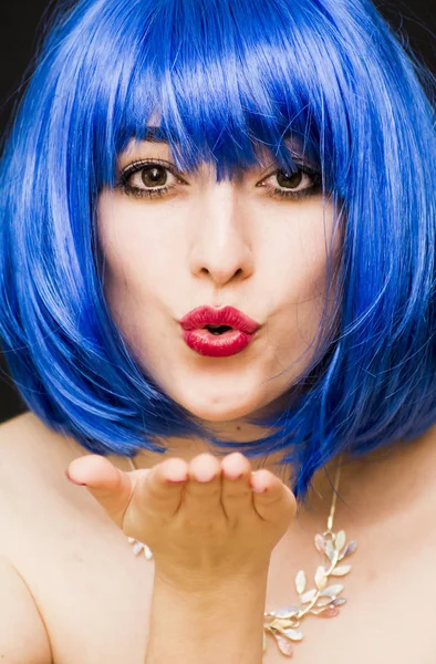 Mulher de beleza em peruca azul e óculos de sol, dando um beijo para o ai Imagens De Bancos De Imagens Sem Royalties