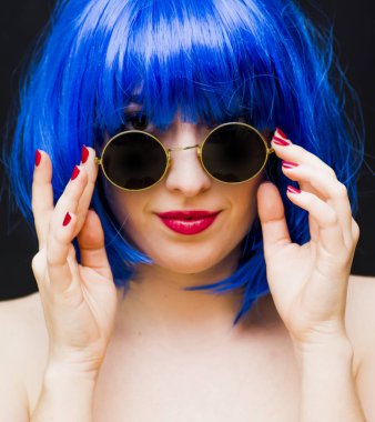 Güzellik kadını mavi peruk ve siyah arka plan üzerinde güneş gözlüğü