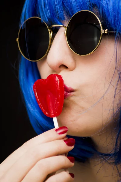 Красавица в синем парике и солнцезащитных очках и держа с ней ч Лицензионные Стоковые Изображения