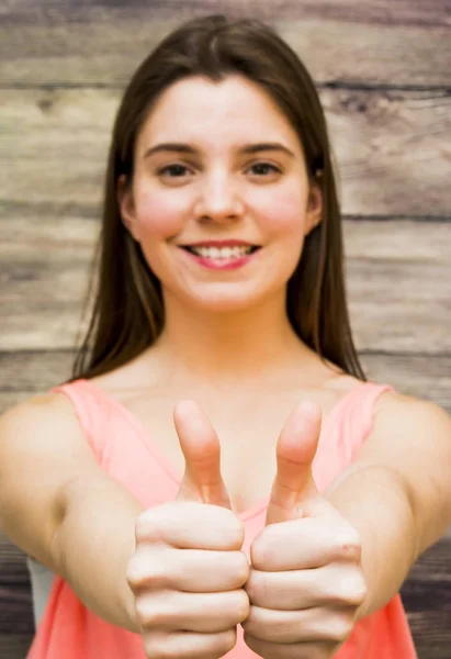 Retrato de uma mulher bonita com o polegar para cima em sinal de optim — Fotografia de Stock