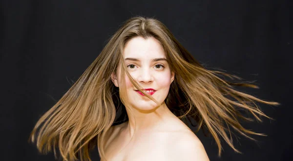 Retrato de una hermosa joven agitando su cabello —  Fotos de Stock