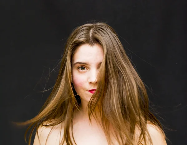 Porträtt av vacker ung kvinna skakar hennes hår — Stockfoto