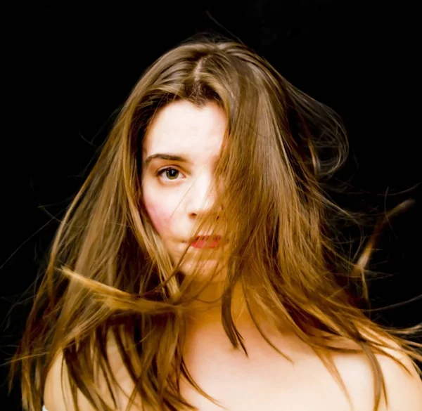 Porträtt av vacker ung kvinna skakar hennes hår — Stockfoto