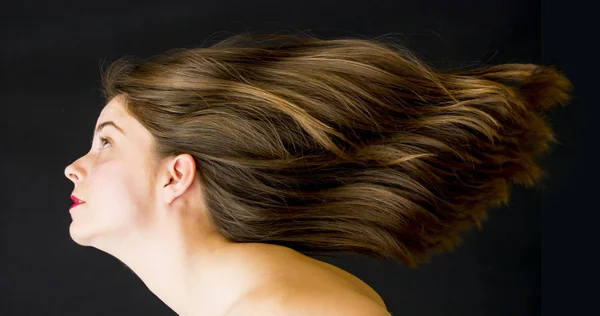 Retrato de una hermosa mujer con el pelo en el viento en ba negro —  Fotos de Stock
