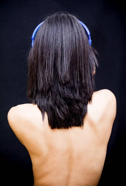 Hermosa mujer con auriculares sobre fondo negro — Foto de Stock