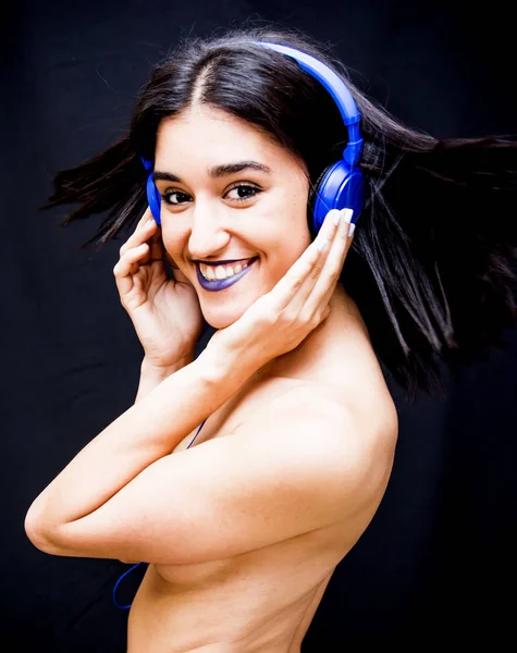 Beautiful woman with headphones on black background — Stock Photo, Image