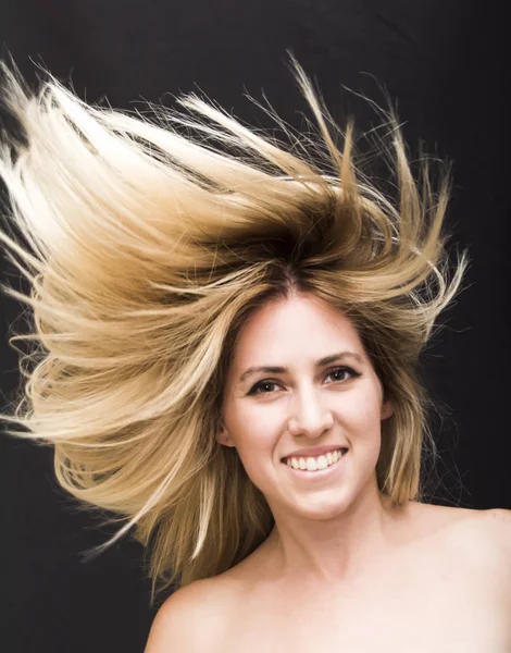 Retrato de una hermosa joven agitando su cabello — Foto de Stock