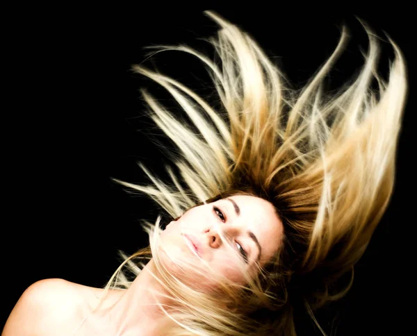 Retrato de una hermosa mujer sacudiendo su cabello en el backgrou negro — Foto de Stock