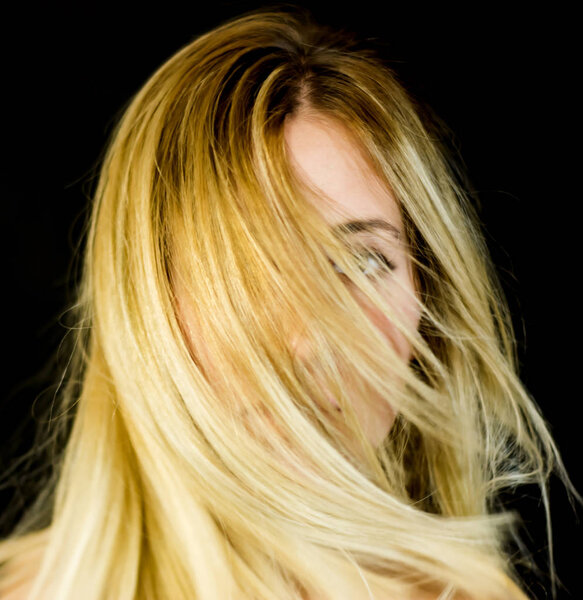 Portrait of a beautiful woman shaking her hair on black backgrou