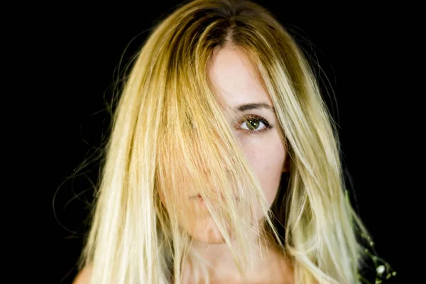 Portrait of a beautiful woman shaking her hair on black backgrou — Stock Photo, Image