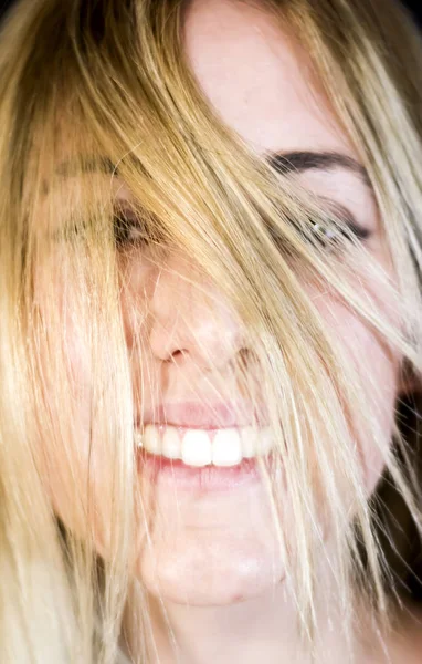 Retrato de uma mulher bonita sacudindo o cabelo no backgrou preto — Fotografia de Stock