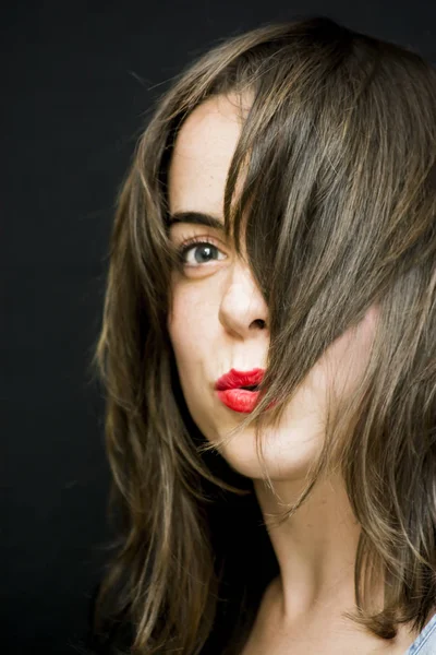 Retrato de una hermosa mujer sacudiendo su cabello en el backgrou negro — Foto de Stock