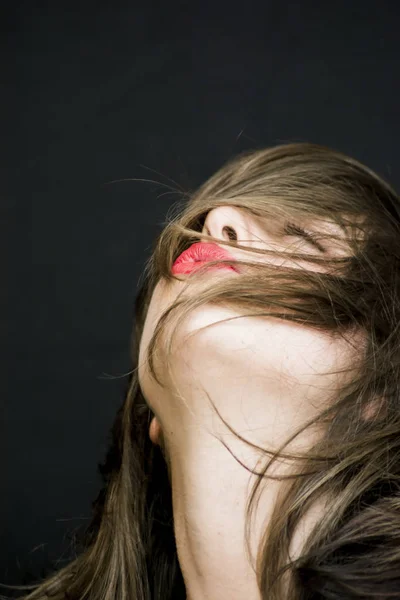 Portret van een mooie vrouw haar haren op zwarte CHTERGRO schudden — Stockfoto