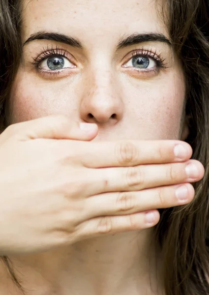 Retrato de una hermosa mujer cubriéndose la boca con la mano — Foto de Stock