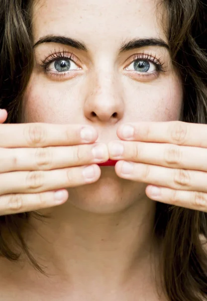 Porträtt av en vacker kvinna som täcker hennes mun med hennes händer — Stockfoto