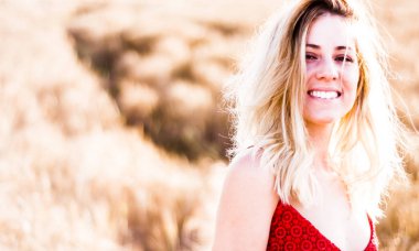 Kırmızı elbiseli, günbatımı buğday sahasının güzel sarışın kadın