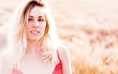 Kırmızı elbiseli, günbatımı buğday sahasının güzel sarışın kadın