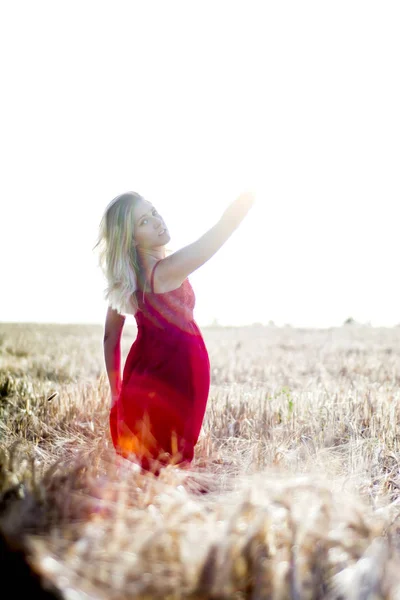 Retrato retroiluminado de mulher loira bonita em um vestido vermelho, em um w — Fotografia de Stock