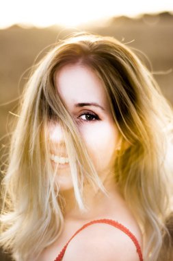 Kırmızı elbiseli, günbatımı buğday sahasının güzel sarışın kadın