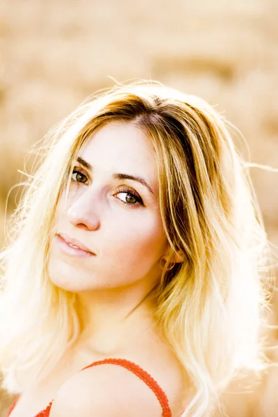 Kırmızı elbiseli, günbatımı buğday sahasının güzel sarışın kadın