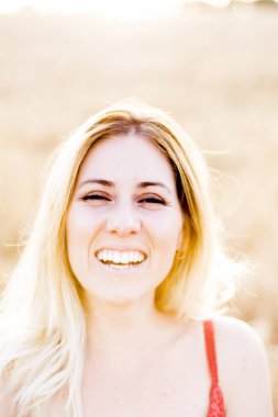 Kırmızı elbiseli, günbatımı buğday sahasının güzel sarışın kadın