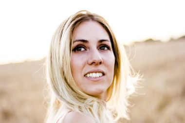 Kırmızı elbiseli, günbatımı buğday sahasının güzel sarışın kadın