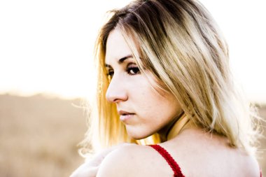 Kırmızı elbiseli, günbatımı buğday sahasının güzel sarışın kadın