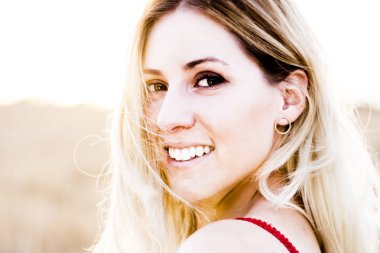 Kırmızı elbiseli, günbatımı buğday sahasının güzel sarışın kadın