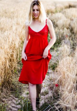 Kırmızı elbiseli, günbatımı buğday sahasının güzel sarışın kadın