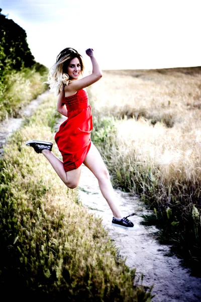 小麦フィールのパスに赤いドレスを着たブロンド美女 — ストック写真