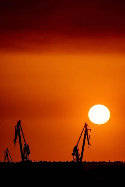起重机在港口与云日落时的风景 — 图库照片