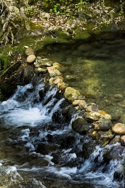 Paesaggio di un fiume con acqua che scorre setosa, rocce e alberi — Foto Stock