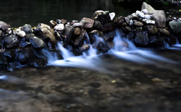 Paisaje de un río con agua corriente sedosa, rocas y árboles —  Fotos de Stock