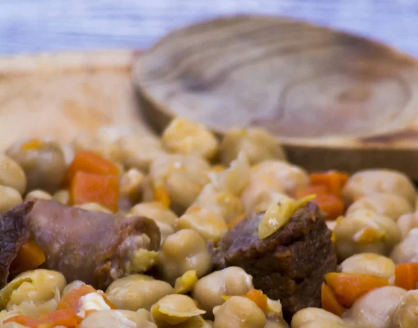 Мадридское рагу на тарелке на деревянном столе, типичная еда от Spai — стоковое фото