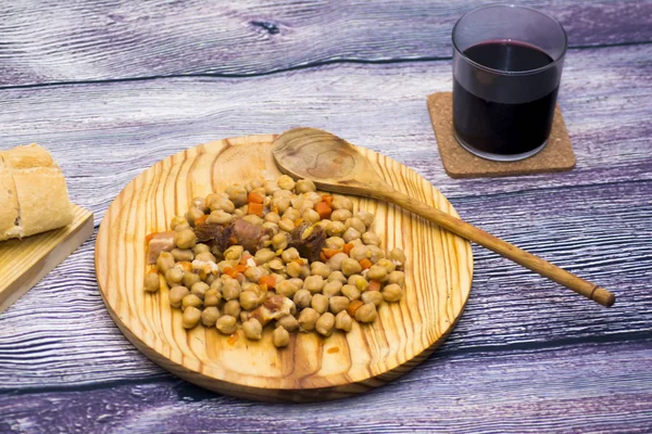 Dušené maso na talíři na dřevěný stůl s chlebem a sklenici Madrid — Stock fotografie